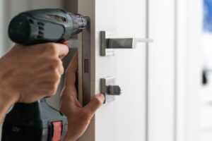 A man repairing doorhandle in the living room