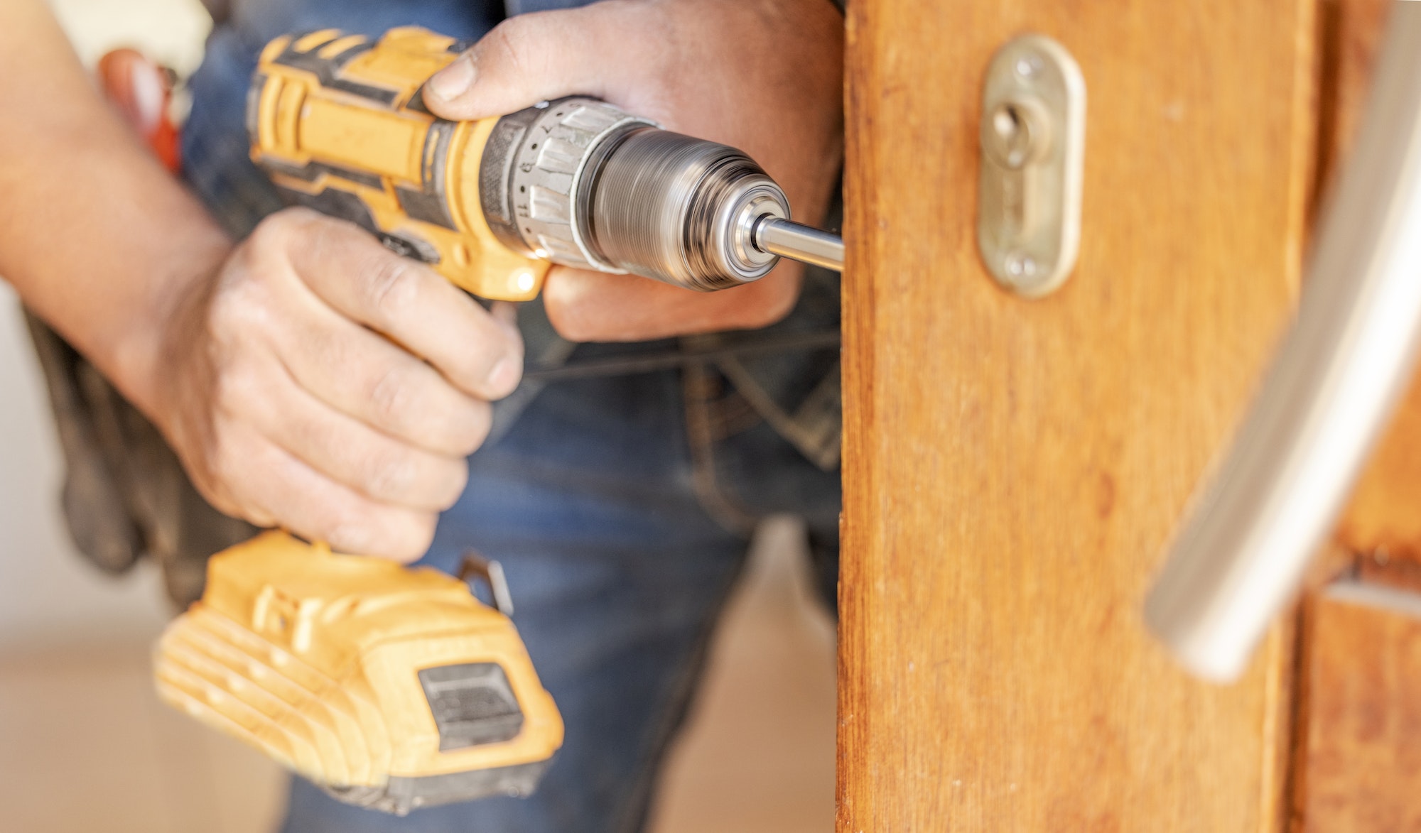 Locksmith hands, maintenance and handyman with construction and fixing, change door locks with tool